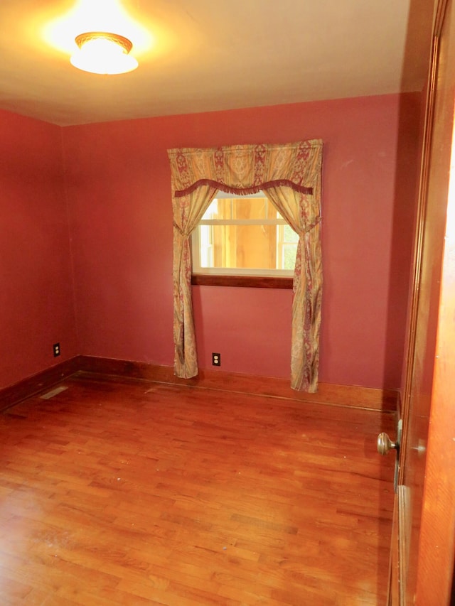 empty room with light wood-style flooring, baseboards, and visible vents