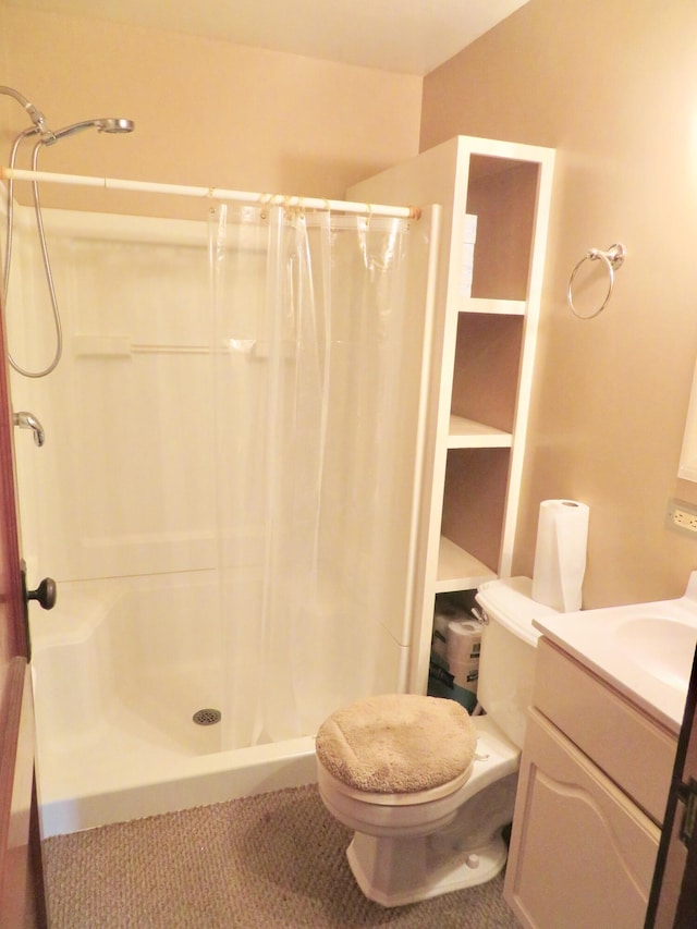 full bath featuring a shower stall, vanity, and toilet