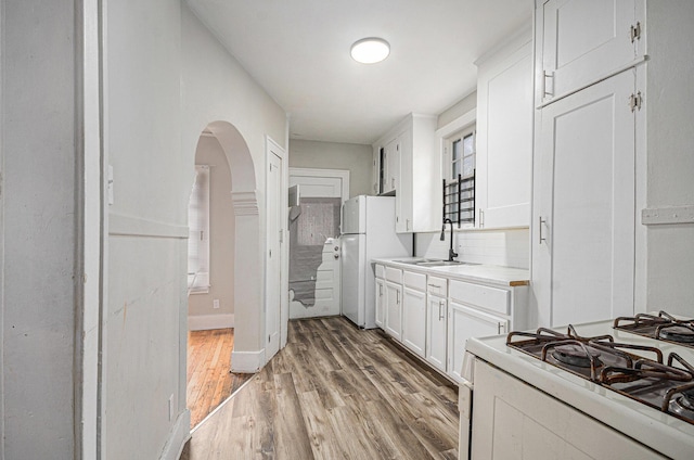13605 Griggs St, Detroit, MI 48238 - kitchen featuring light wood-type flooring, light countertops, white appliances, and white cabinets