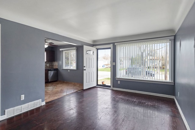 unfurnished living room with visible vents, baseboards, wood finished floors, and a healthy amount of sunlight