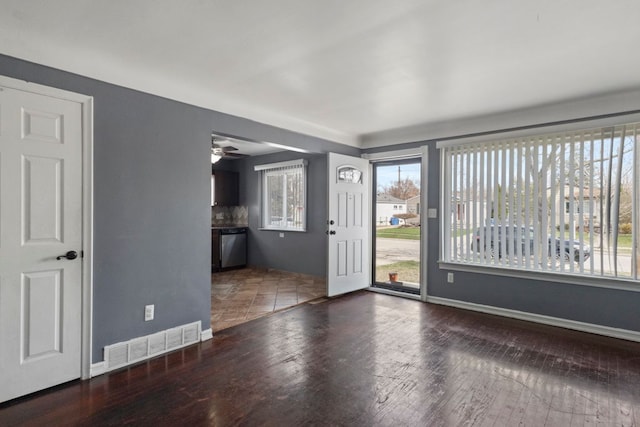 unfurnished living room featuring wood finished floors, baseboards, and visible vents