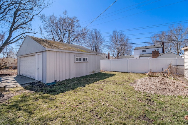 view of yard featuring a garage, fence, and an outdoor structure