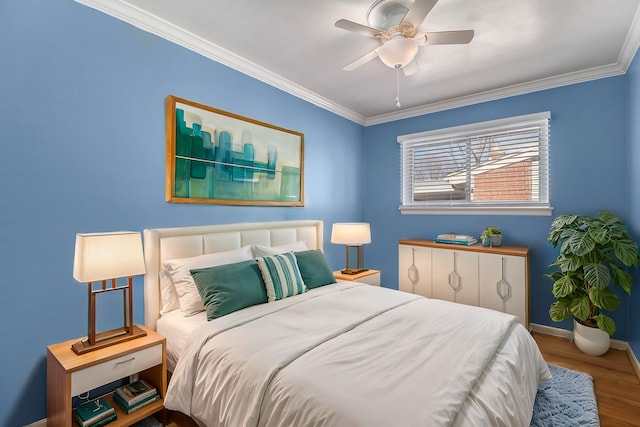 bedroom with crown molding, wood finished floors, baseboards, and a ceiling fan