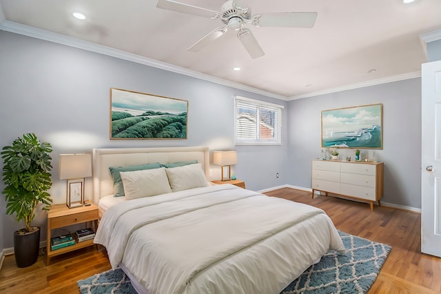 bedroom with crown molding, wood finished floors, and baseboards
