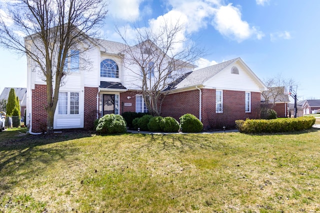 traditional home featuring brick siding and a front lawn