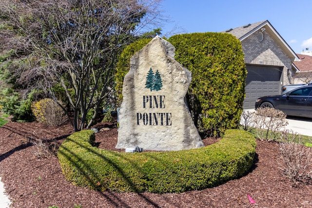 community / neighborhood sign featuring an attached garage