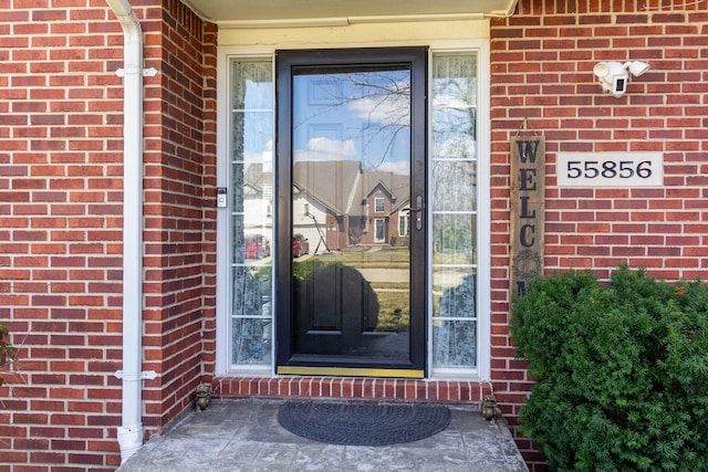 property entrance featuring brick siding