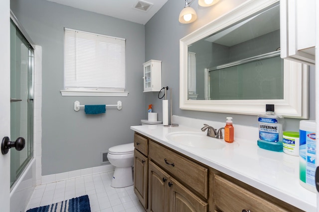 bathroom with tile patterned floors, toilet, vanity, baseboards, and enclosed tub / shower combo