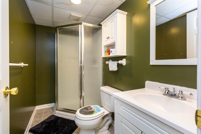 full bathroom with a drop ceiling, toilet, a stall shower, vanity, and baseboards