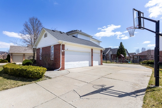 view of property exterior featuring brick siding, fence, concrete driveway, a garage, and roof with shingles