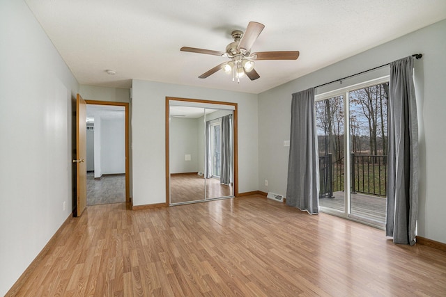 spare room featuring baseboards, visible vents, light wood-type flooring, and a ceiling fan