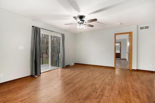 spare room featuring light wood-style flooring, visible vents, baseboards, and a ceiling fan