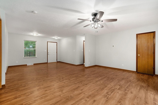 spare room with light wood finished floors, visible vents, baseboards, and a ceiling fan