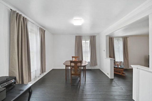 dining space featuring dark wood-style flooring, baseboards, and ornamental molding