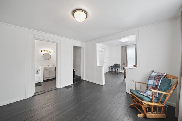 sitting room featuring dark wood-style flooring, baseboards, and visible vents