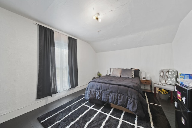 bedroom featuring wood finished floors and lofted ceiling