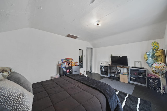 bedroom with wood finished floors, visible vents, and lofted ceiling