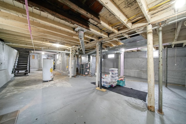 unfinished basement with gas water heater, stairway, and heating unit