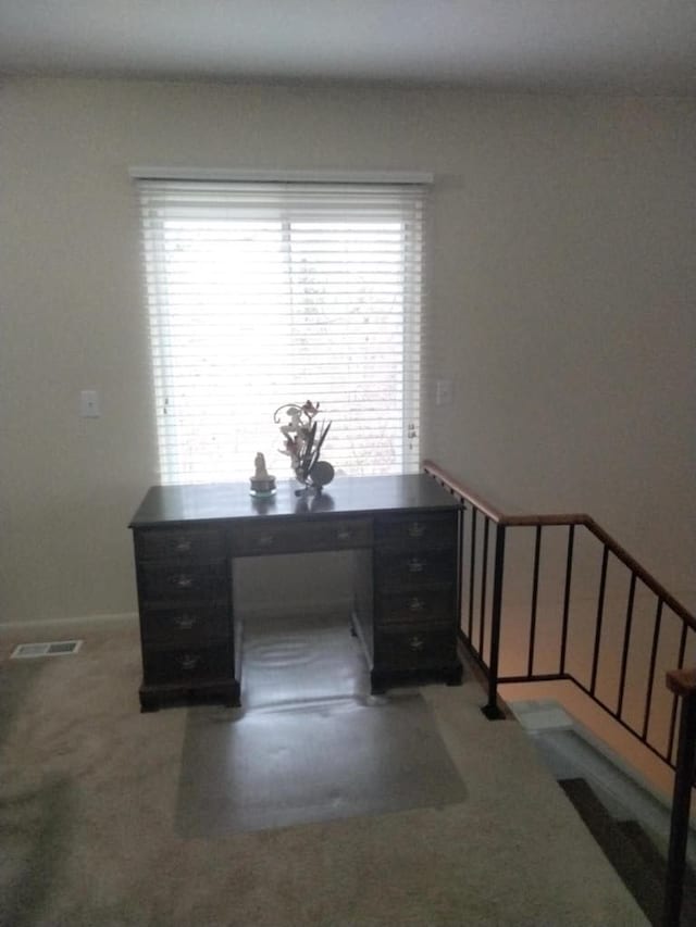 carpeted office space with visible vents and baseboards