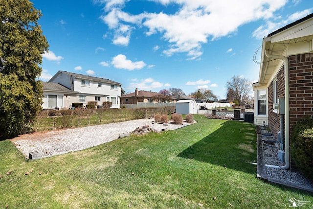 view of yard featuring a storage shed, cooling unit, an outdoor structure, fence, and a residential view