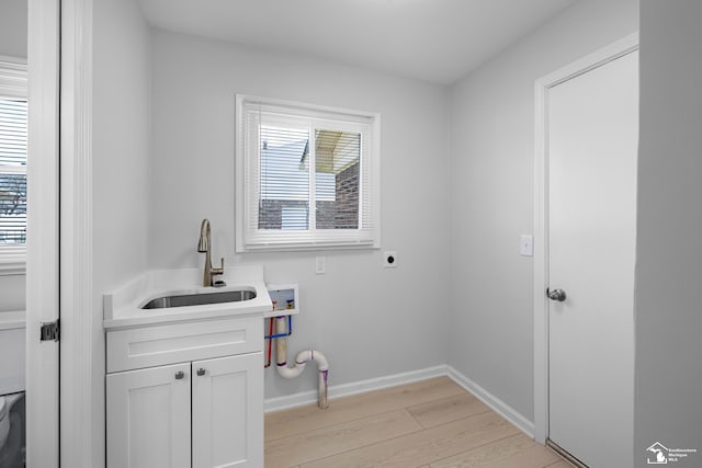 laundry room with light wood-style floors, electric dryer hookup, washer hookup, a sink, and cabinet space
