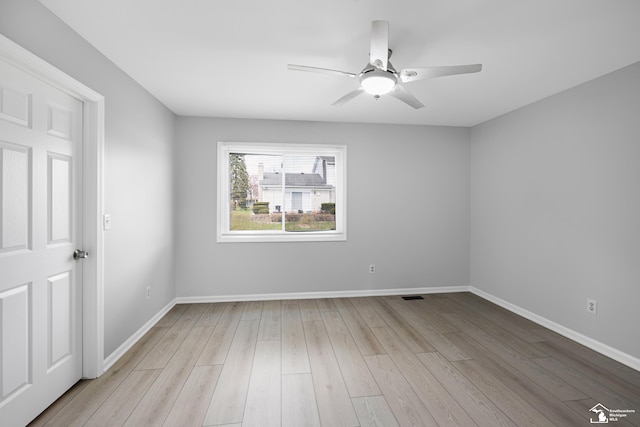 unfurnished room featuring light wood-style floors, visible vents, baseboards, and a ceiling fan