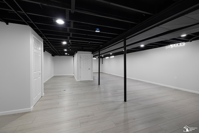 finished basement featuring baseboards and wood finished floors
