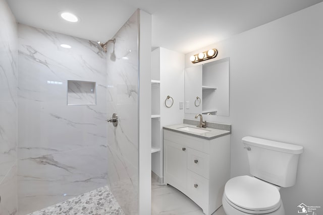 bathroom featuring toilet, marble finish floor, vanity, and a marble finish shower