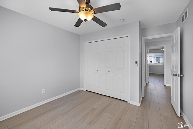unfurnished bedroom featuring visible vents, baseboards, a closet, ceiling fan, and light wood-type flooring
