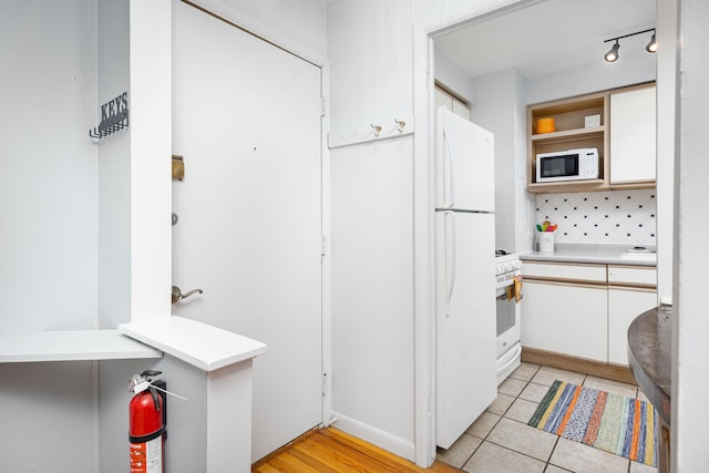 1209 Island Dr Unit 102, Ann Arbor, MI 48105 - kitchen with white appliances, open shelves, light countertops, and white cabinets