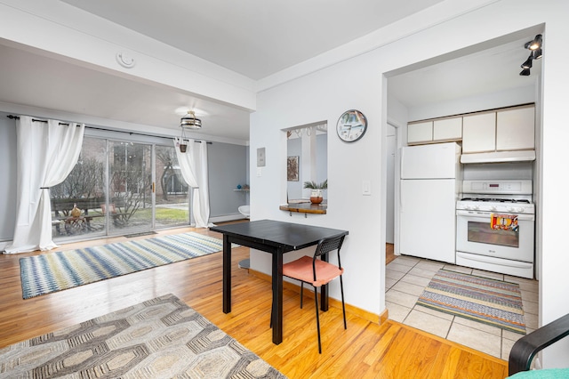 1209 Island Dr Unit 102, Ann Arbor, MI 48105 - dining room featuring light wood-style flooring, a baseboard radiator, baseboards, and crown molding