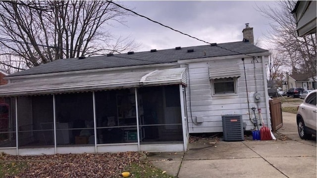 8021 Trafalgar St, Taylor, MI 48180 - rear view of property with central AC, a shingled roof, a sunroom, and a chimney