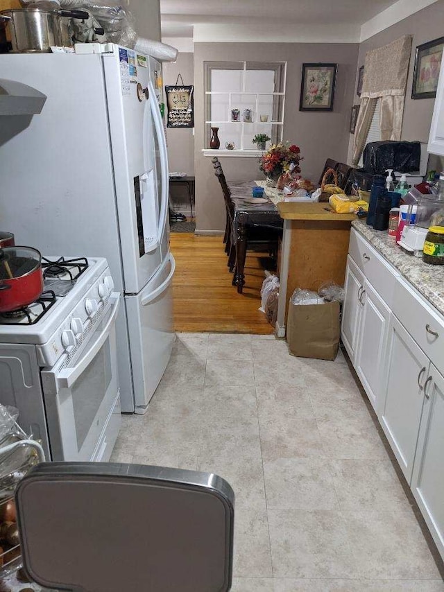 8021 Trafalgar St, Taylor, MI 48180 - kitchen featuring light tile patterned floors, white cabinets, white appliances, and light countertops