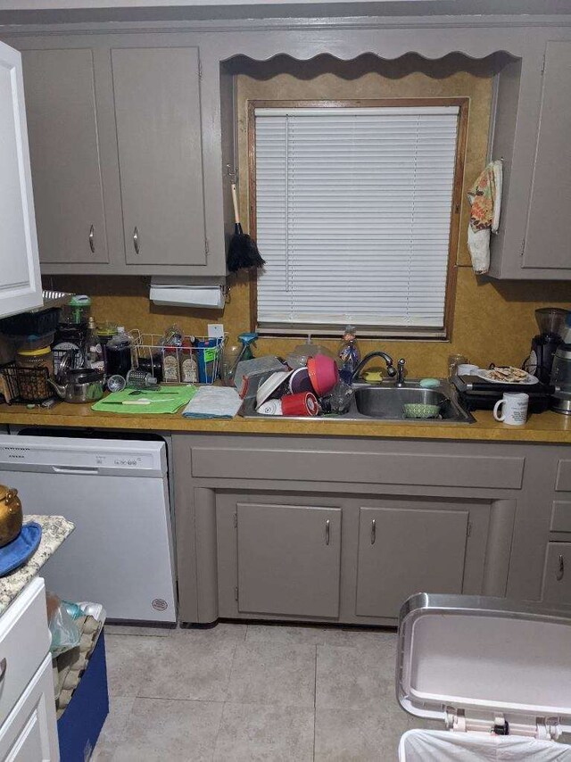 8021 Trafalgar St, Taylor, MI 48180 - kitchen featuring light tile patterned floors, light countertops, gray cabinetry, white dishwasher, and a sink