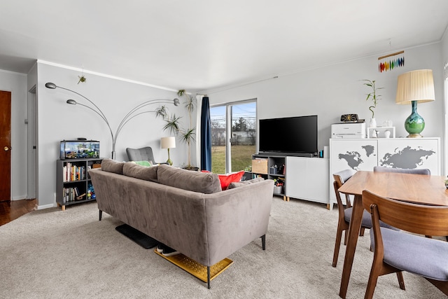 living area featuring crown molding, baseboards, and light carpet