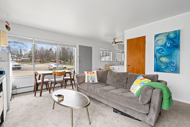 living room with carpet floors, a baseboard heating unit, and a healthy amount of sunlight