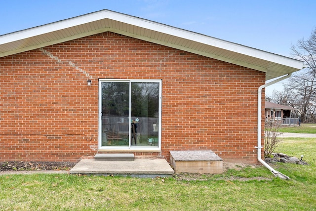 exterior space with a lawn and brick siding
