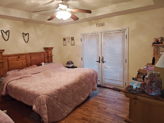 5409 N Mckinley Rd, Flushing, MI 48433 - bedroom with wood finished floors, access to outside, a ceiling fan, and a raised ceiling
