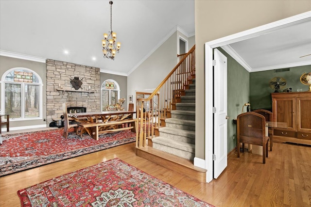 interior space featuring a stone fireplace, crown molding, and wood finished floors