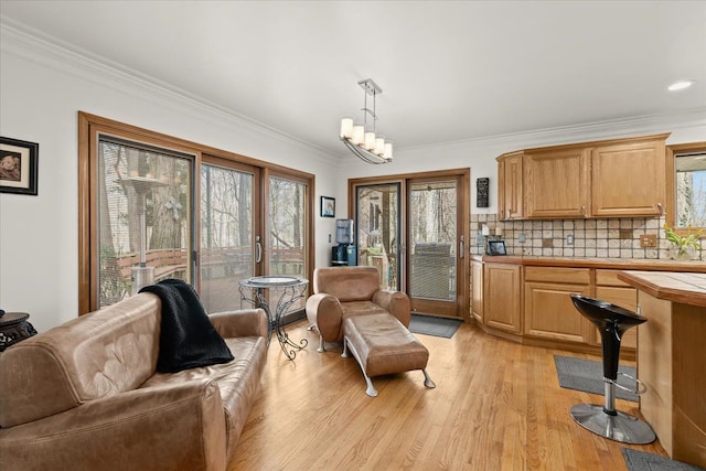 living area featuring light wood-style flooring and crown molding