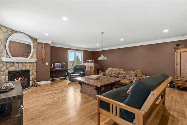 living area with crown molding, a stone fireplace, light wood-style flooring, baseboards, and recessed lighting