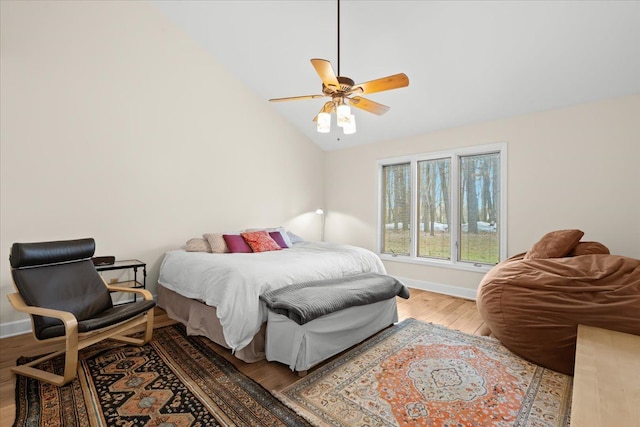 bedroom featuring ceiling fan, vaulted ceiling, wood finished floors, and baseboards