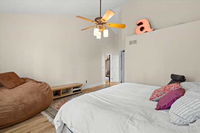 bedroom featuring light wood-style flooring, baseboards, visible vents, ceiling fan, and high vaulted ceiling