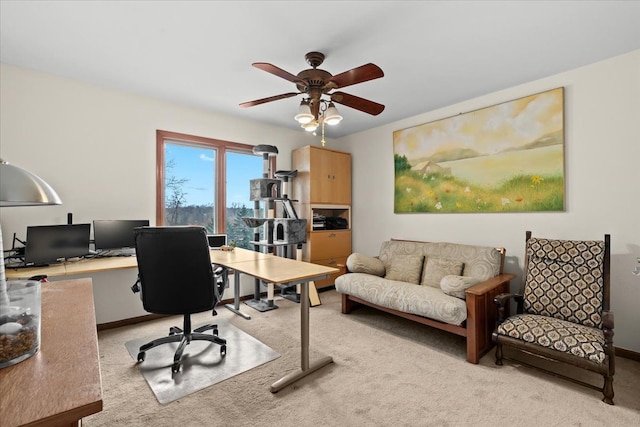 carpeted home office with a ceiling fan and baseboards