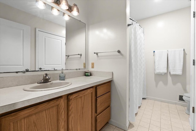 bathroom featuring tile patterned floors, vanity, baseboards, toilet, and visible vents