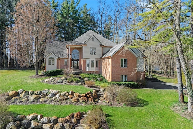 traditional-style home featuring a front yard and brick siding