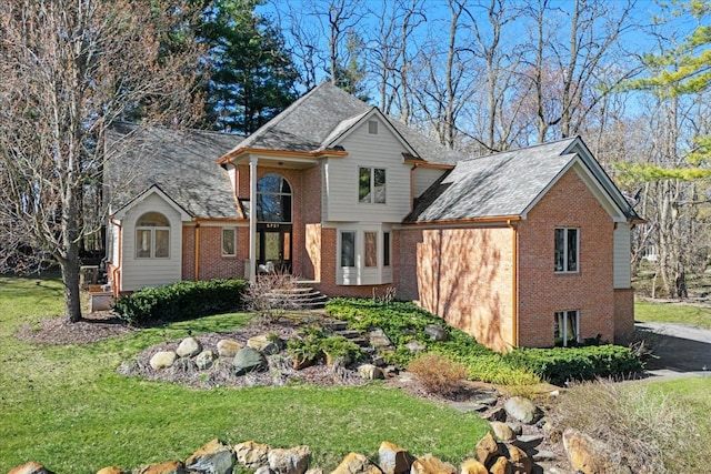 traditional-style house with a front yard and brick siding