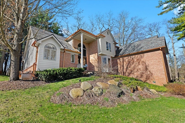 view of front of property featuring a front yard and brick siding