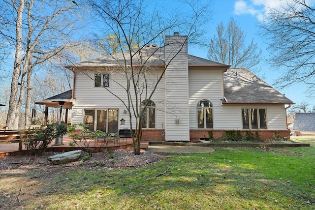 back of house featuring a chimney, a patio, roof with shingles, and a lawn