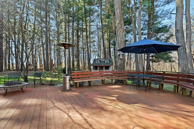 wooden terrace with outdoor dining area and an outdoor fire pit